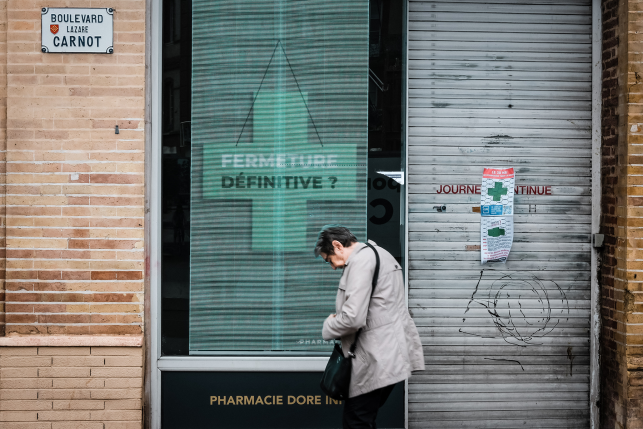Woman in front of closed pharmacy window