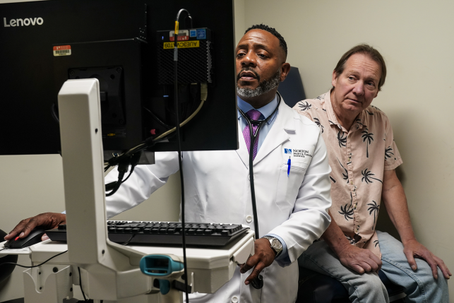 Doctor looks at computer scren in front of patient