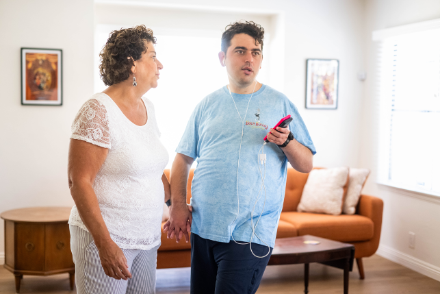 Woman and adult son hold hands