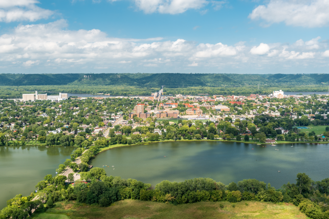 Aerial photo of Winona, Minnesota showing a town along a large river with hills in the background