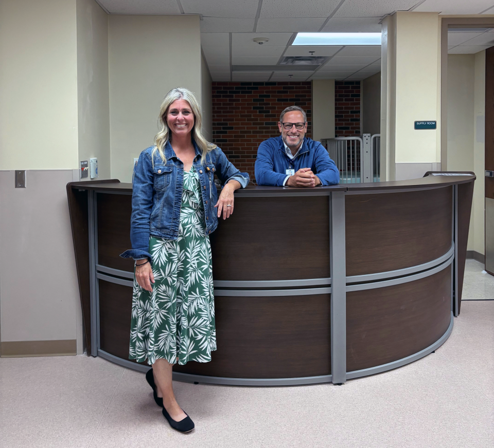 Woman and man posing for photograph inside a hospital reception area