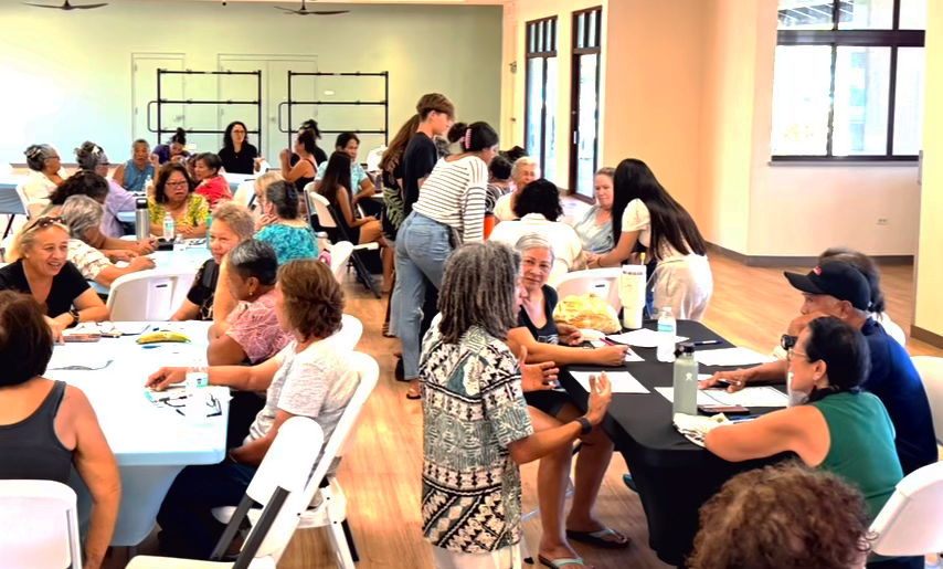 Gathering of people around tables in a community setting having discussions