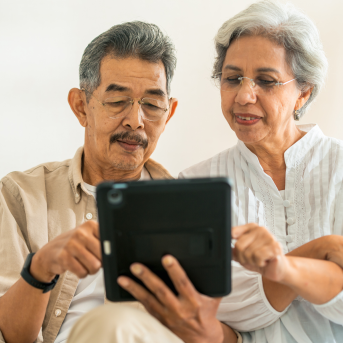 Elderly man and woman work on tablet