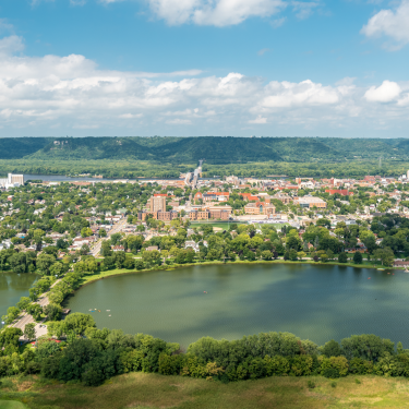 Aerial photo of Winona, Minnesota showing a town along a large river with hills in the background