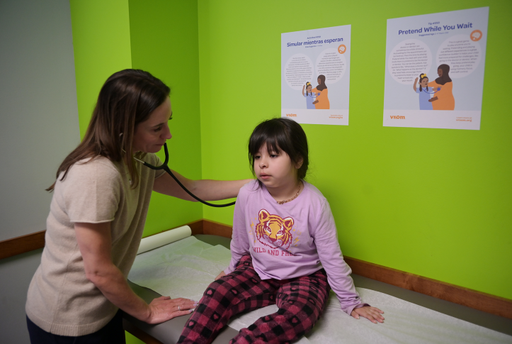 Doctor examines young girl on medical bed