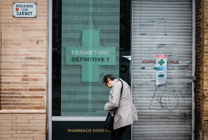 Woman in front of closed pharmacy window