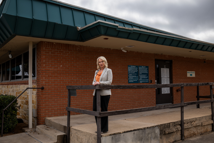 Woman stands in front of brick building