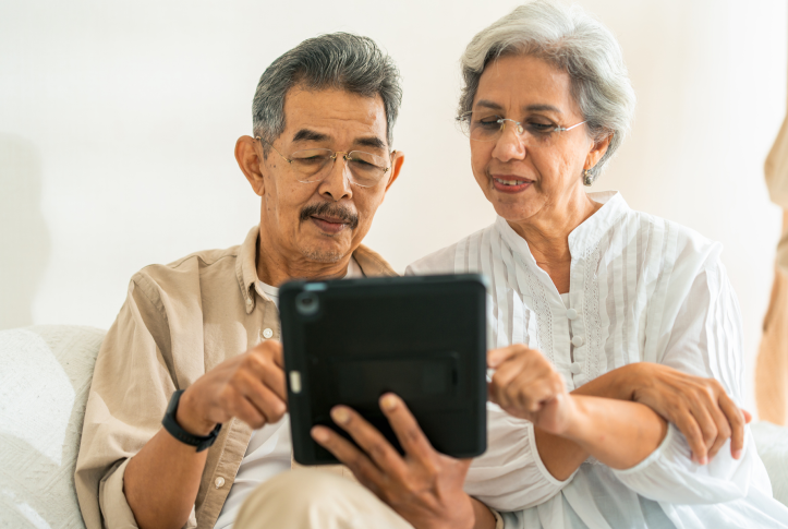 Elderly man and woman work on tablet