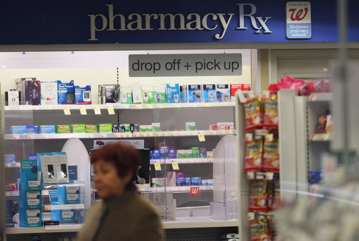 Woman walks in front of pharmacy counter