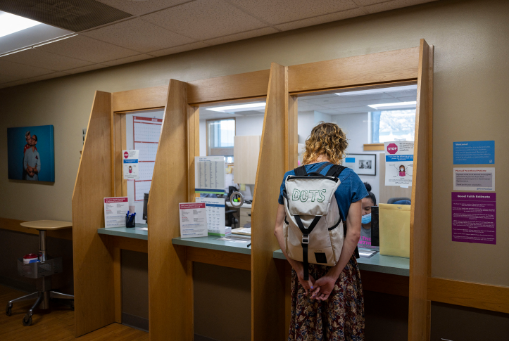 Woman with backpack checks in at clinic desk