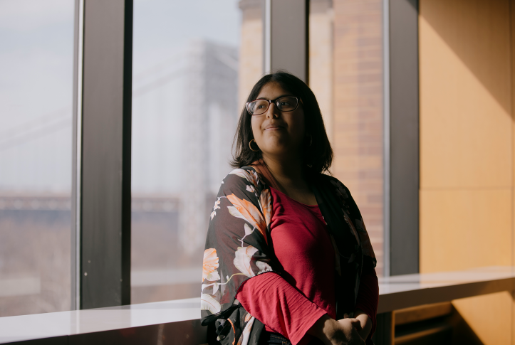 Woman looking in the distance in front of city scape.