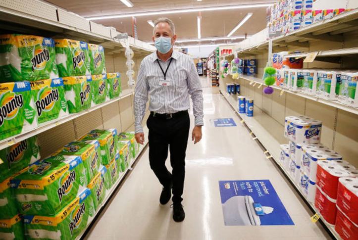 Senior worker in grocery store ready for COVID-19