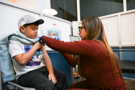 Nurse gives a child a vaccine in an office