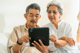 Elderly man and woman work on tablet