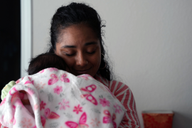 Doula snuggles baby in blanket